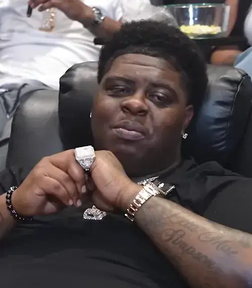 BigXthaPlug seated in a black leather chair showing a diamond ring during a 2026 interview